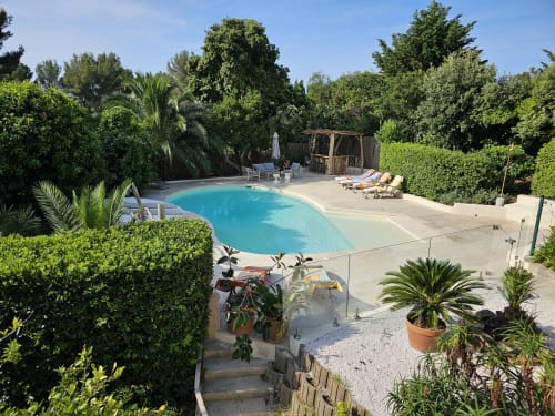 Piscine turquoise à la Villa Sigahi, boutique hôtel à La Croix Valmer, entourée de jardins luxuriants et de transats