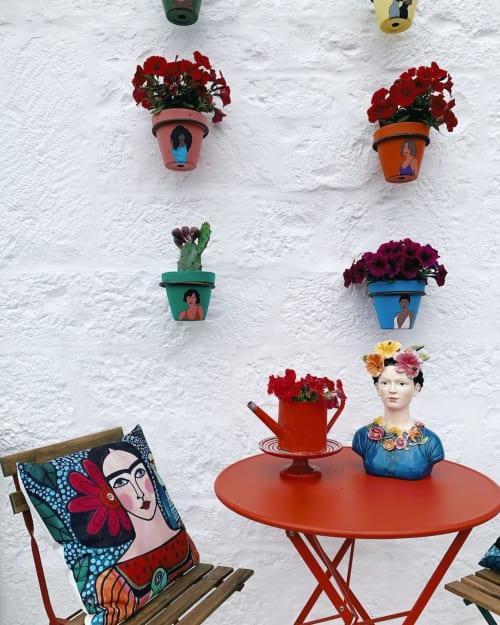 Vasi di fiori dipinti colorati e decorazioni fantastiche su muro bianco a CorteLirice Paradiso, Italia