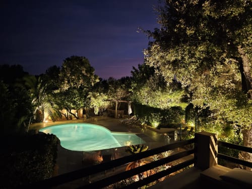 Piscine illuminée à la Villa Sigahi B&B à La Croix Valmer, entourée d'arbres luminescents au crépuscule
