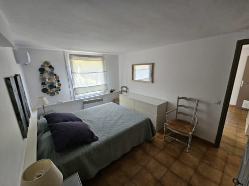 Chambre lumineuse à la Villa Sigahi à La Croix Valmer avec lit, commode, fenêtre vue jardin et parquet