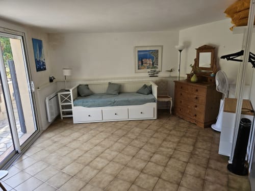 Chambre lumineuse de l'appartement Villa Sigahi, La Croix Valmer, avec lit de jour blanc, commode en bois et accès à la vue jardin