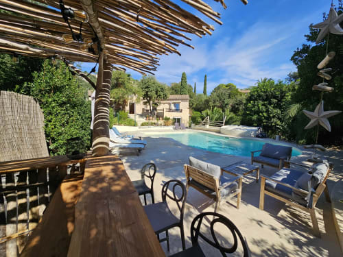 Espace piscine de la Villa Sigahi avec chaises longues, pergola en bois et villa méditerranéenne à La Croix Valmer