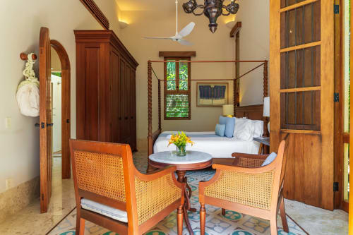 Lujosa habitación de la villa Hacienda Chekul en Tulum con cama dosel, muebles de madera y decoración tropical