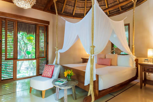 Lujosa cama dosel en villa Hacienda Chekul, Tulum con cortinas blancas, vistas tropicales y mobiliario de madera