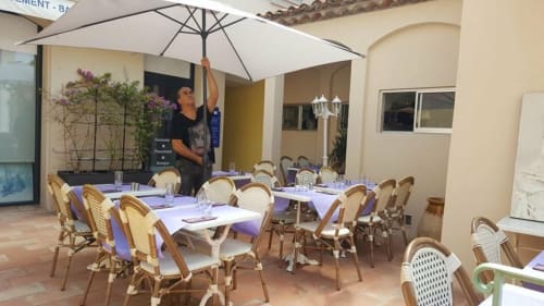 Outdoor dining patio at Villa Sigahi B&B in La Croix Valmer with wicker chairs, white umbrellas, and purple accents