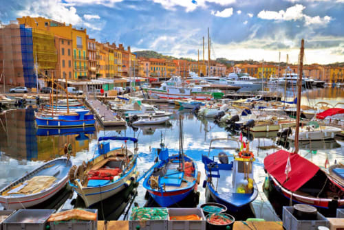 Colorful boats in picturesque Mediterranean harbor with yellow buildings, near Villa Sigahi in La Croix Valmer, France