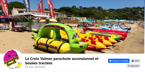 Équipements colorés de sports nautiques sur la plage de La Croix Valmer avec installations de parachute ascensionnel
