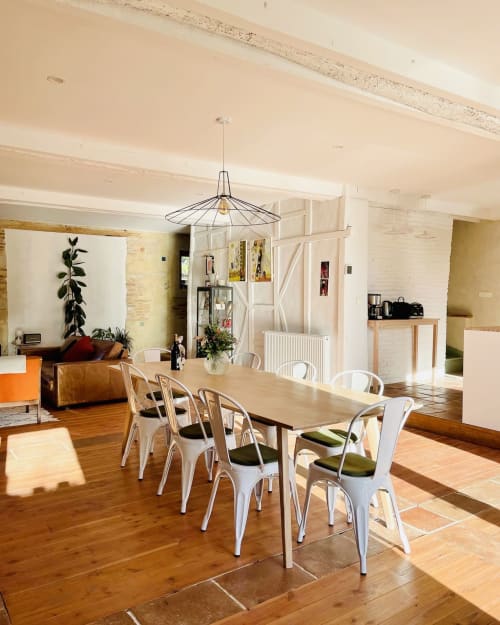 Salle à manger de villa moderne avec chaises blanches, table en bois et luminaire suspendu industriel à la Maison Monsieur Léger à Montaut