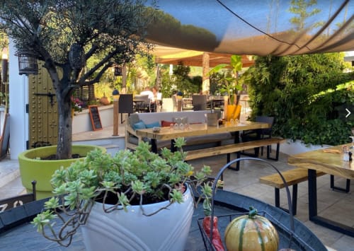 Terrasse extérieure de la Villa Sigahi avec tables en bois, plantes grasses et pergola ombragée à La Croix Valmer
