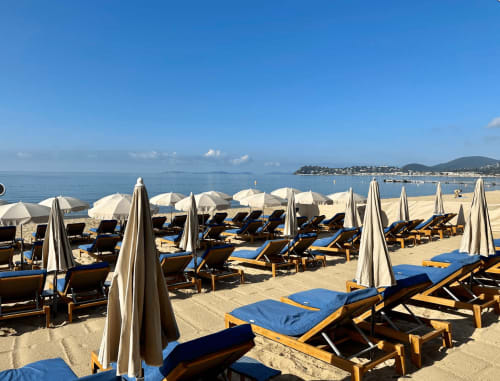 Zone de détente à la plage de la Villa Sigahi à La Croix Valmer avec parasols et transats bleus face à la Méditerranée