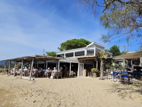 Restaurant de plage à Villa Sigahi, La Croix Valmer, avec terrasse de sable et clients sous des structures ombragées