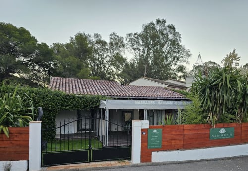 Eingang zum Villa Sigahi Gästehaus in La Croix Valmer mit eingezäunter Auffahrt und tropischer Bepflanzung