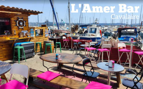 L'Amer Bar Cavalaire beachfront dining with colorful chairs and sailboats, La Croix Valmer