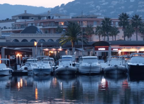 Villa Sigahi waterfront at dusk with moored boats and Mediterranean buildings in La Croix Valmer