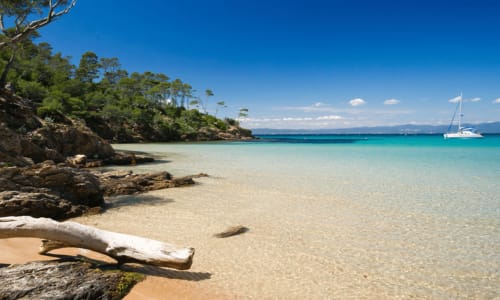 Magnifique plage turquoise de Villa Sigahi à La Croix Valmer avec sable blanc, voilier et pins