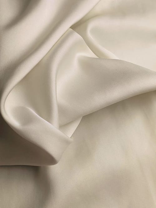 Drap blanc en satin soie délicatement plissé