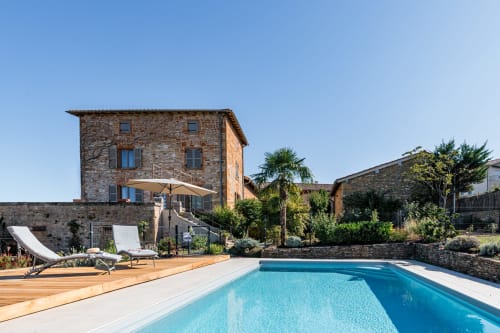 piscine et sa terrasse en bois avec chaises longues, maison de pagneux, chambres d'hôtes en Beaujolais des Pierres dorées