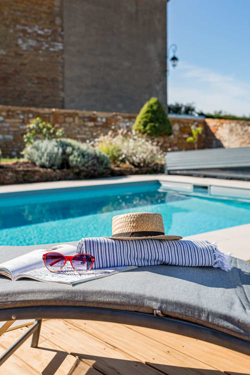 transat au bord de la piscine, avec lunettes de soleil, chapeau et serviette, maison de pagneux, chambres d'hôtes en Beaujolais des Pierres dorées