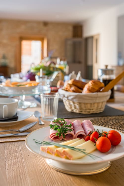 Assiette de fromage et jambon et viennoiseries pour le petit déjeuner, maison de pagneux, chambres d'hôtes en Beaujolais des Pierres dorées