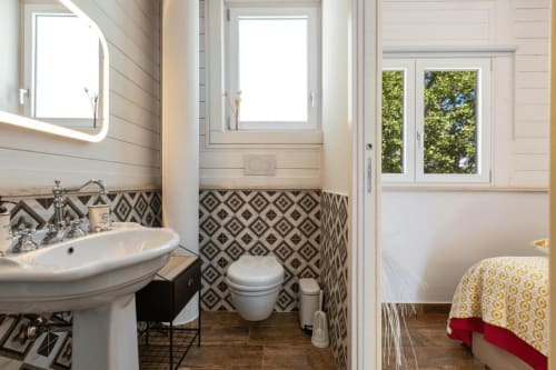 Bagno moderno a Villa Margherita con piastrelle geometriche, lavabo a colonna e vista su Santeramo in Colle