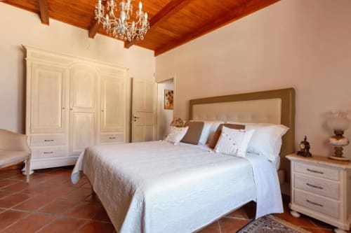 Camera da letto elegante a Villa Margherita con soffitto in legno, lampadario e arredamento tradizionale a Santeramo in Colle
