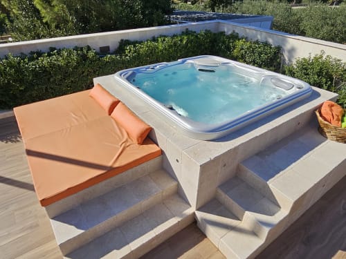 Vasca idromassaggio esterna con acqua turchese e sdraio arancione a Villa Margherita, Santeramo in Colle
