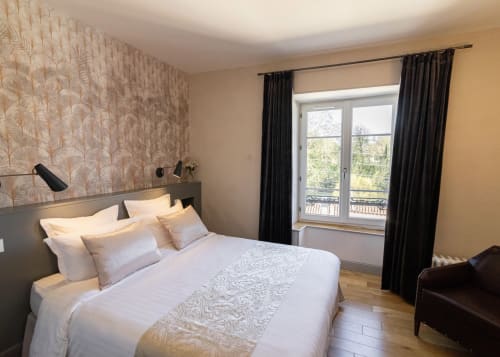 Elegant bedroom at Clos des Moulins B&B Poitiers with white bedding, patterned wallpaper, black curtains, and river views
