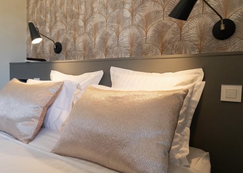 Luxurious bed with gold decorative pillows at Clos des Moulins B&B in Poitiers, featuring elegant palm-patterned headboard.