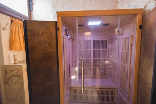 Infrared sauna cabin at CasaRosada B&B in Vidracco with pink lighting and wooden frame