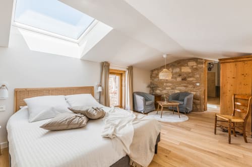 Lit double et fenêtre de toit au dessus du lit, coin salon, mur en pierres apparentes, chambre air, maison de pagneux, chambres d'hôtes en Beaujolais des Pierres dorées 