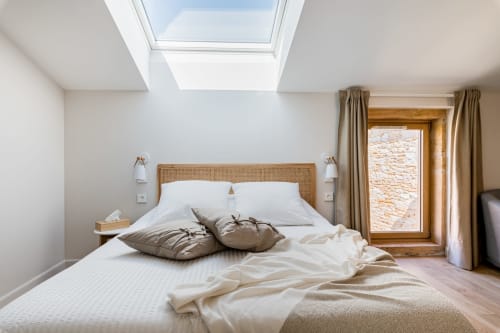 lit double avec fenêtre de toit au dessus du lit, et fenêtre entourée de rideaux à droite du lit, chambre air, maison de pagneux, chambres d'hôtes en Beaujolais des Pierres dorées 