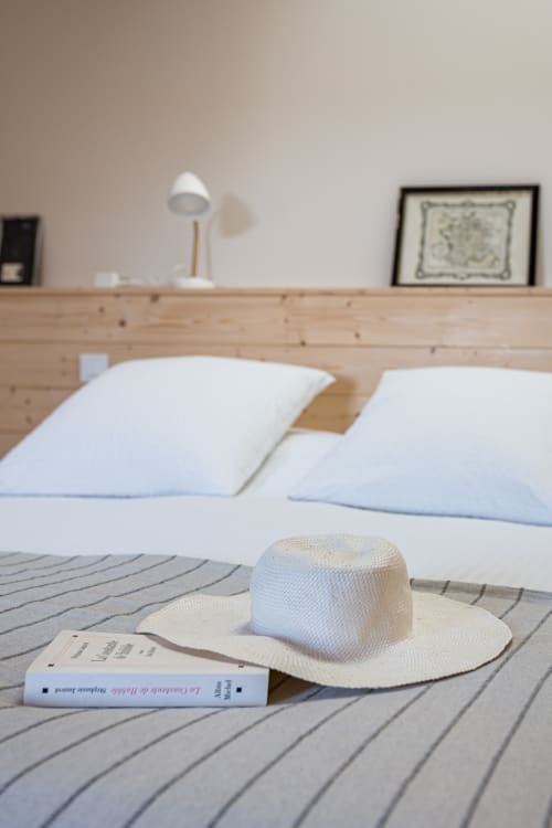 détail de livre et chapeau sur le lit, chambre bois, maison de pagneux, chambres d'hôtes en Beaujolais des Pierres dorées 