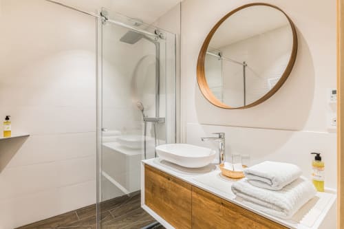 Salle de bain avec miroir rond en bois et meuble vasque blanc et bois, douche italienne, chambre bois, maison de pagneux, chambres d'hôtes en Beaujolais des Pierres dorées