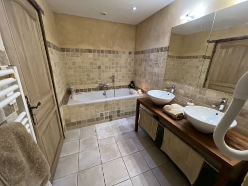 Salle de bains luxueuse au Lapin sur le Toit avec vasques doubles, baignoire balnéo et sèche-serviettes électrique