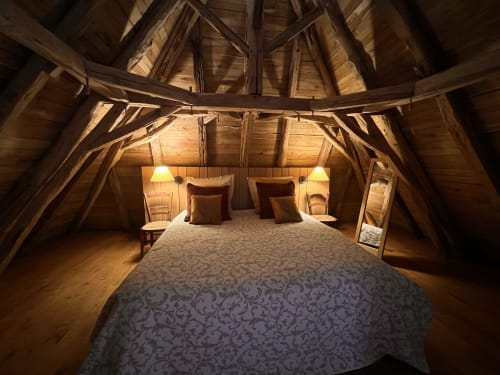 Chambre douillette sous les toits au Lapin sur le Toit : poutres en bois, lit queen-size, lampes de chevet et charme rustique à Rouffignac, France