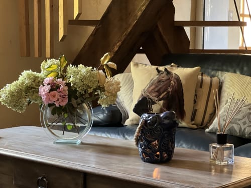 Élégant décor du Lapin sur le Toit : fleurs d'hortensia fraîches, portrait équin et chouette décorative sur table en bois