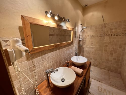 Salle de bain moderne au Lapin sur le Toit avec vasques doubles, meuble en bois, grand miroir éclairé et douche à l'italienne