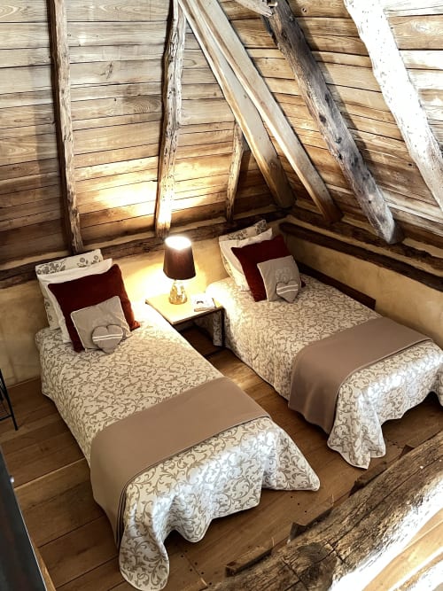 Chambre douillette du gîte Le Lapin sur le Toit à Rouffignac avec lits jumeaux, poutres apparentes et ambiance chaleureuse