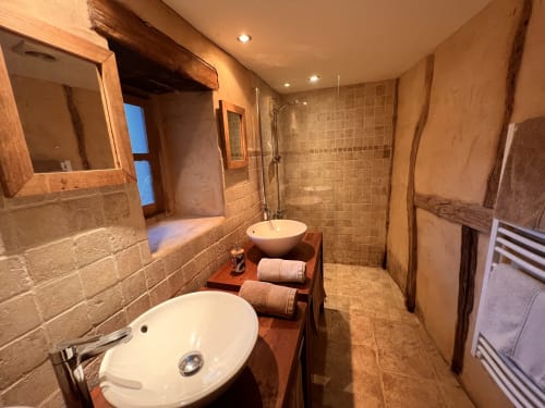 Salle de bain luxueuse au gîte Le Lapin sur le Toit avec vasques doubles, douche à l'italienne et radiateur sèche-serviettes à Rouffignac, France