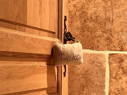 Porte rustique en bois avec étiquette en tissu au gîte Le Lapin sur le Toit à Rouffignac, France
