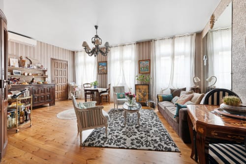 Élégant séjour du gîte Au Nid De La Madeleine à Gaillac avec mobilier en bois, papier peint rayé et fenêtres