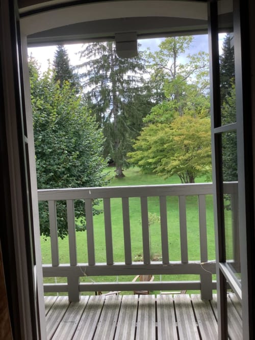 Vue depuis le balcon de La Barbizonaise sur la pelouse aménagée et la forêt de Barbizon