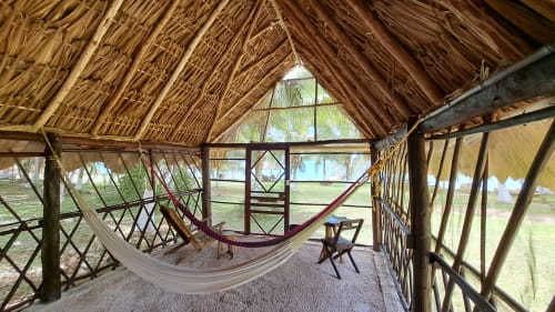 Palapa con techo de paja en el hostel Cayuco Maya de Bacalar con hamacas con vistas al lago