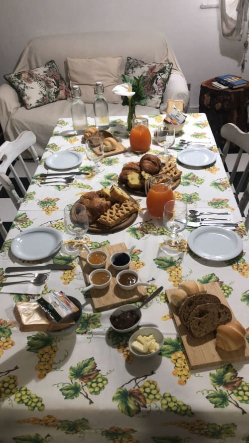 Tavola della colazione all'Agriturismo Il Pomo d'oro con pasticcini, pane, marmellate, succhi e fiori freschi ad Assemini