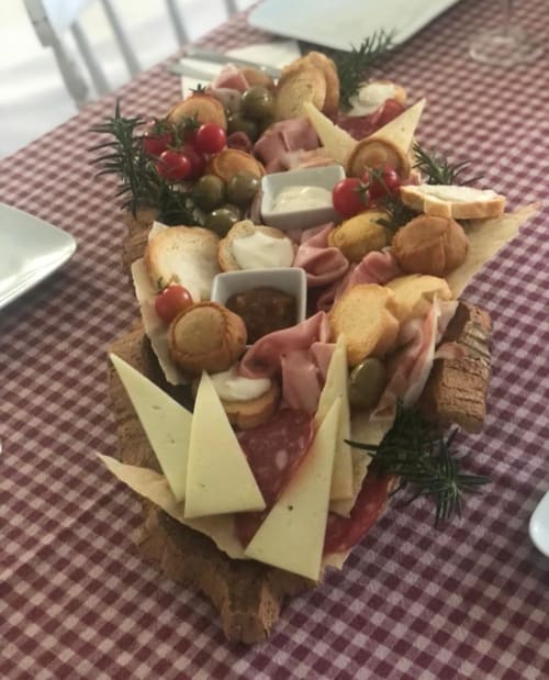 Tagliere gastronomico con formaggi, salumi, olive e pane all'Agriturismo Il Pomo d'oro di Assemini