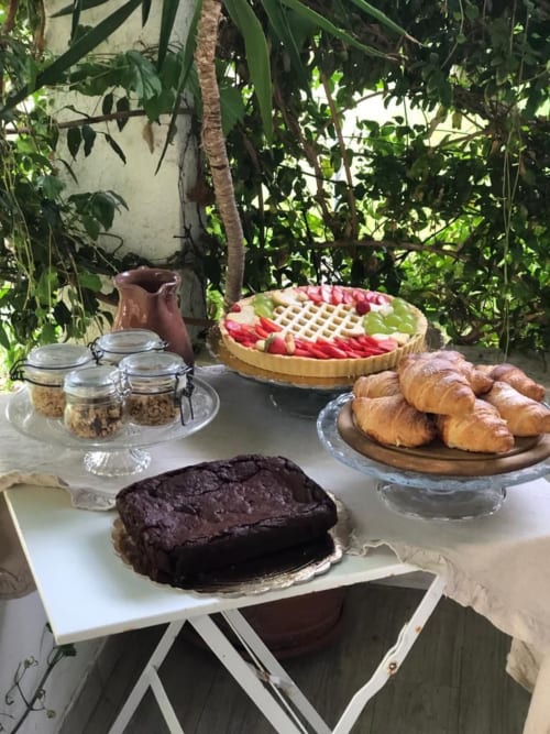 Colazione all'aperto all'Agriturismo Il Pomo d'oro: torta al cioccolato, crostata di frutta, cornetti, cereali e brocca in terracotta