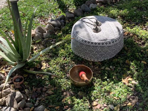 Spazio meditativo nel giardino di Agriturismo Il Pomo d'oro con cuscino, ciotola di ottone e piante grasse