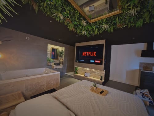 Titre : Aventure en Jungle : Séjour Inoubliable à Saint-Jean-Bonnefonds**
   Préparez-vous pour une aventure en jungle dans notre chambre Jungle, idéalement située à Saint-Jean-Bonnefonds, près de Saint-Étienne dans la Loire. Plongez dans une atmosphère sauvage et immersive avec une décoration luxuriante et des détails inspirés de la nature. Détendez-vous dans notre jacuzzi entouré de verdure, puis profitez d'une soirée cinéma sur notre écran de 189 cm avec Netflix, face au lit et à la jungle qui vous entoure.