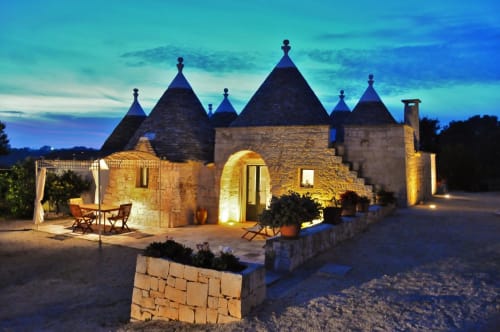 Trulli Vulés a Ostuni, Italia - caratteristiche case trulli con tetti conici illuminati al tramonto