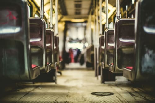 Interno di un autobus di trasporto pubblico con sedili rossi, maniglie cromate e corridoio centrale a Leuca, Italia